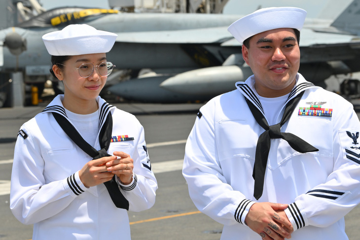 Huyền Trân và Carlos Nguyễn đón khách tham quan tàu sân bay USS Ronald Reagan - Ảnh: DUY LINH